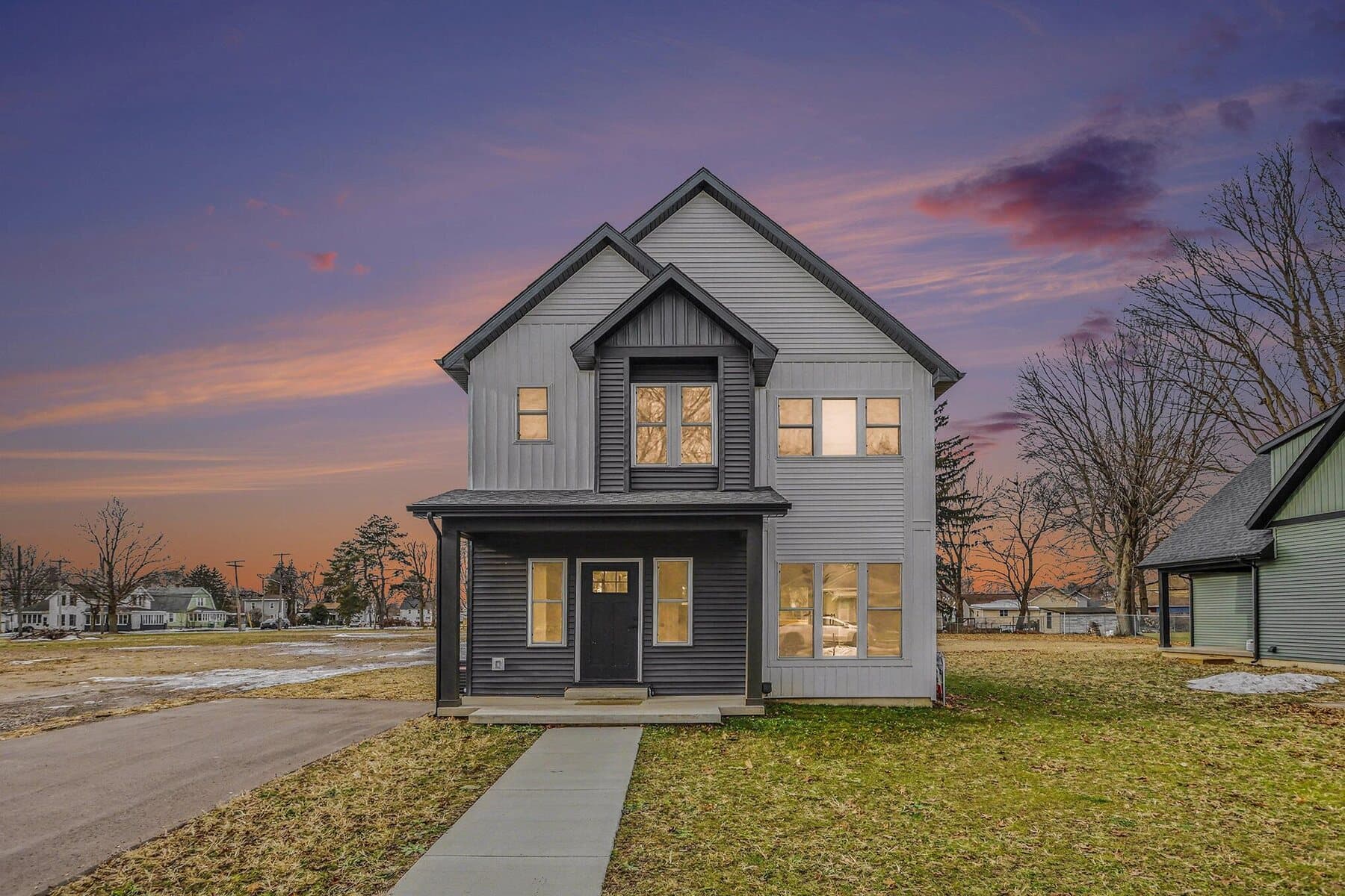 Two-story home with a covered front porch at sunset