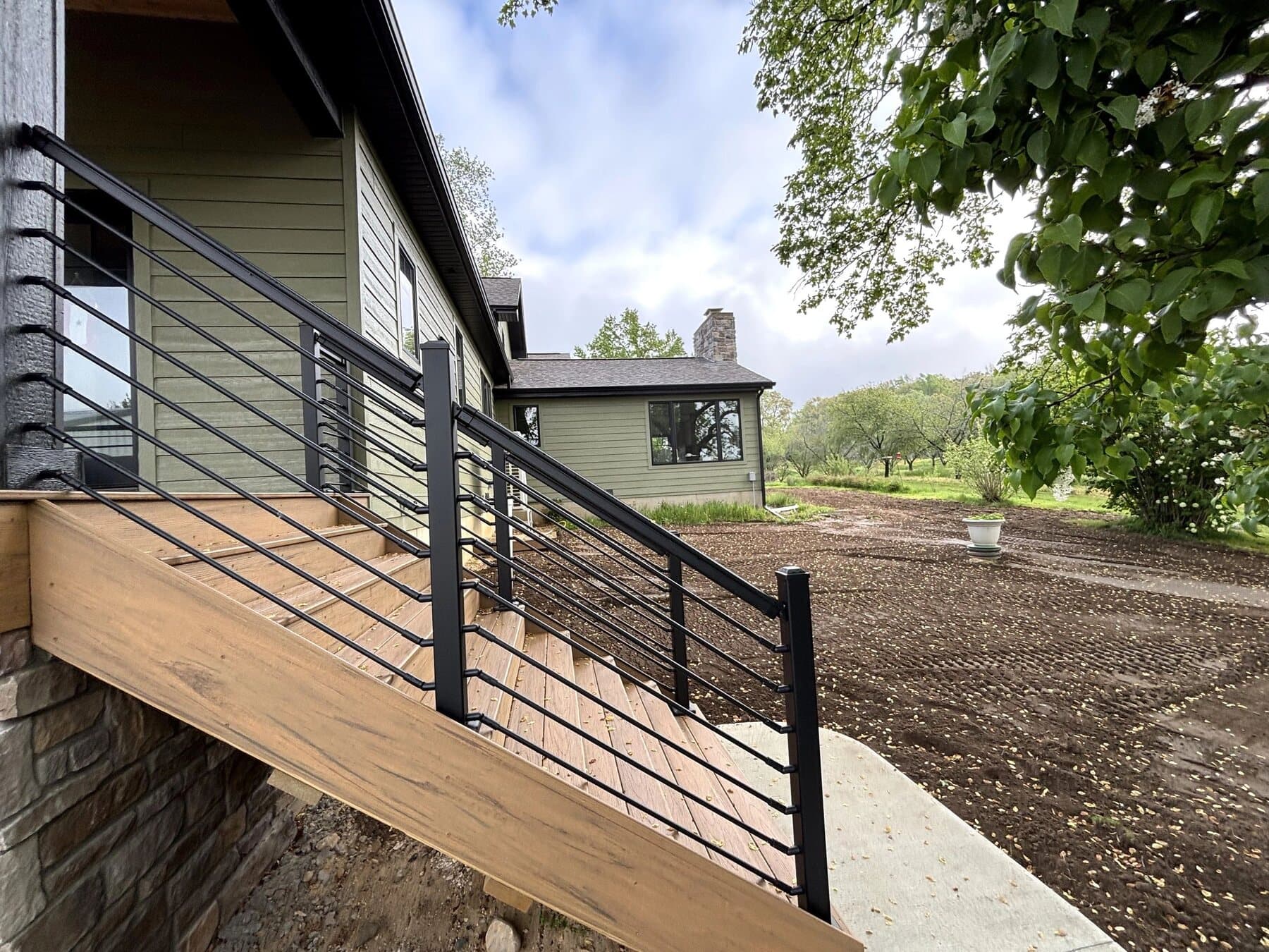 Rear elevation of a custom home with a raised deck and cable railing