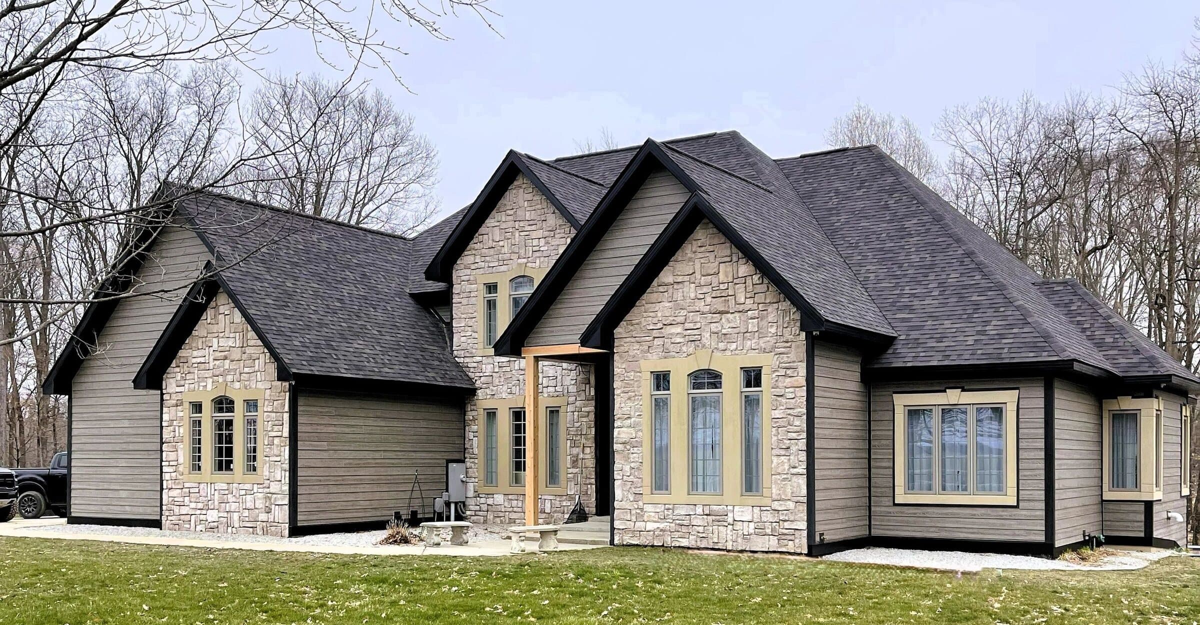 Stone and siding custom home with steep gables and arched windows